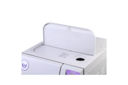 Фрагмент верхньої частини автоклава TANVO обємом 45 літрів, що демонструє систему подачі води. На фото видно круглий вхідний отвір для дистильованої води, розташований праворуч, та захисну кришку водяного відсіку, яка закриває частину верхньої панелі.