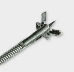 Металевий дистальний кінець біопсійних щипців з відкритими овальними чашечками, що мають центральну голку. Видно гнучкий катетер