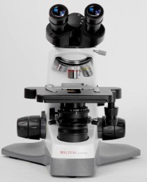 Фото ветеринарного мікроскопа LED DAFFODIL MCX-100. Зображення показує ключові частини приладу, насадку, револьвер з обєктивами та основний корпус з ручками фокусування.