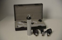 Компоненти ветеринарного набору LTI-109 на фоні відкритого футляру. На передньому плані зображені металева рукоятка, головка офтальмоскопа, головка отоскопа та носовий розширювач з байонетним кріпленням