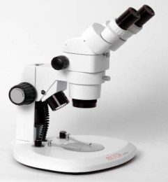 Білий стереомікроскоп з бінокулярною насадкою, двома джерелами освітлення і круглою основою. Використовується для обємного перегляду зразків