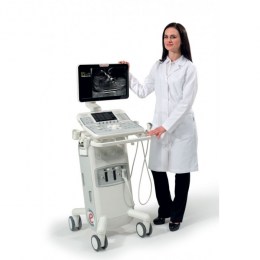 На фото жінка ветеринар у білому халаті стоїть біля ультразвукового апарату MyLab x5 Vet. На екрані видно УЗД-зображення. Знімок демонструє, як апарат слугує професійним діагностичним інструментом у щоденній роботі лікаря