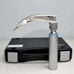 Ветеринарний ларингоскоп з клинком Macintosh у зборі, встановлений на рукоятку, на фоні чорного пластикового кейсу для зберігання