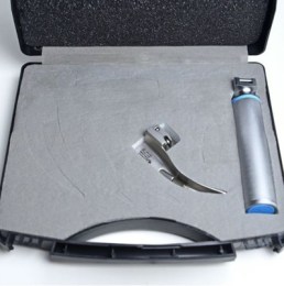 Відкритий кейс з ларингоскопним набором: у ложементі окремо лежать металева рукоятка та вигнутий клинок типу Macintosh